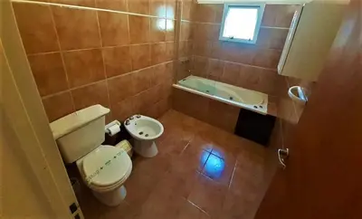 a small bathroom with a toilet and a sink at Hosteria Aguaribay in Mina Clavero