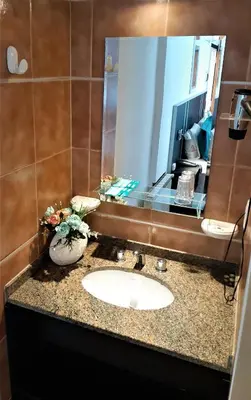 a bathroom with a sink and a mirror at Hosteria Aguaribay in Mina Clavero