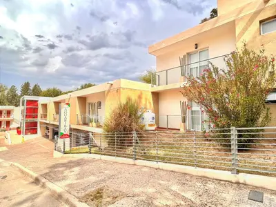 a building with a fence in front of it at Hosteria Aguaribay in Mina Clavero