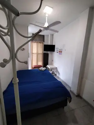 a bedroom with a blue bed and a ceiling fan at Habitación para 2 personas con baño privado in Cordoba