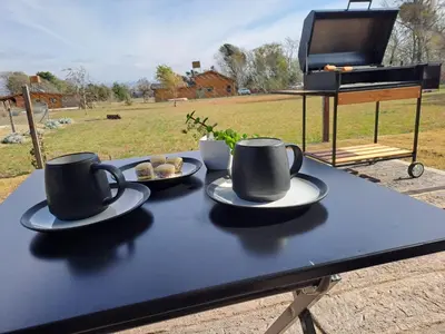 a table with two coffee cups and a piano at Hada del Champaqui - Posada de Montaña in Villa General Belgrano