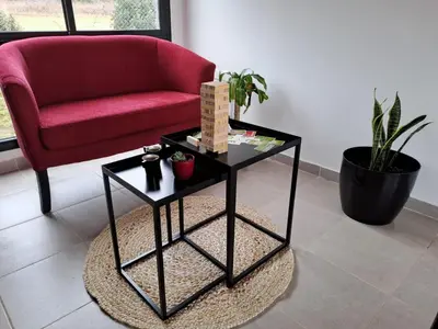 a living room with a red couch and a table at Hada del Champaqui - Posada de Montaña in Villa General Belgrano