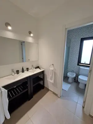 a bathroom with a sink and a mirror and a toilet at Hada del Champaqui - Posada de Montaña in Villa General Belgrano