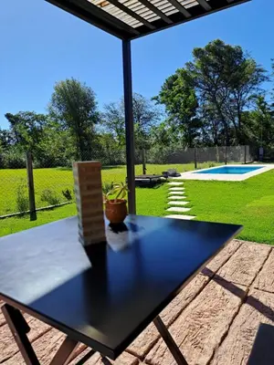 a black table on a patio with a view of a pool at Hada del Champaqui - Posada de Montaña in Villa General Belgrano