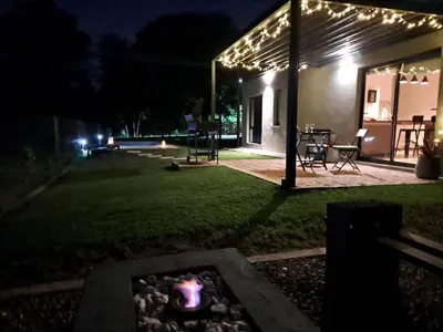 a backyard at night with a fire pit and lights at Hada del Champaqui - Posada de Montaña in Villa General Belgrano