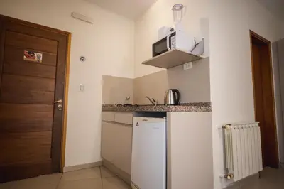 a small kitchen with a refrigerator and a microwave at Altos del Champaqui in Villa Carlos Paz