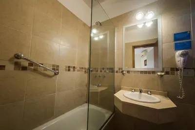 a bathroom with a shower and a sink and a mirror at Altos del Champaqui in Villa Carlos Paz