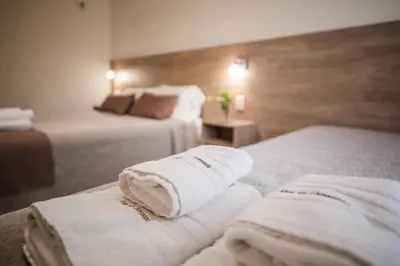 a hotel room with two beds with towels on them at Altos del Champaqui in Villa Carlos Paz