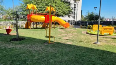 a playground with a slide in a park at Hermoso departamento temporario en zona centro a metros de la terminal e importantes hospitales in Cordoba