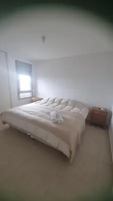 a large white bed in a bedroom with a window at Hermoso departamento temporario en zona centro a metros de la terminal e importantes hospitales in Cordoba