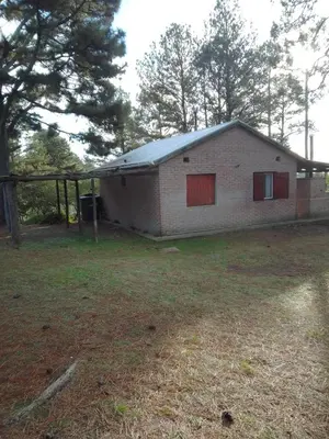 a brick house with red doors in a yard at Luna Plateada - Terrafirme in Villa Yacanto