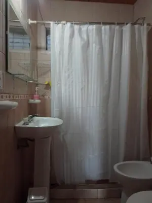a bathroom with a white shower curtain and a sink at Luna Plateada - Terrafirme in Villa Yacanto