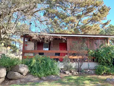 a house with a red door in a yard at Luna Plateada - Terrafirme in Villa Yacanto