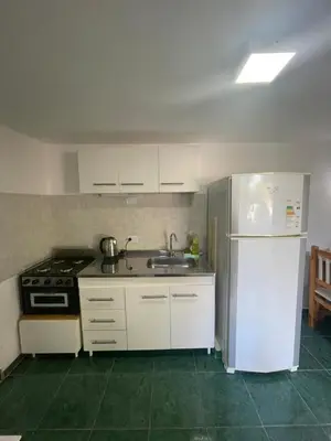 a kitchen with a white refrigerator and a sink at Monoambiente El Sosiego in Alta Gracia