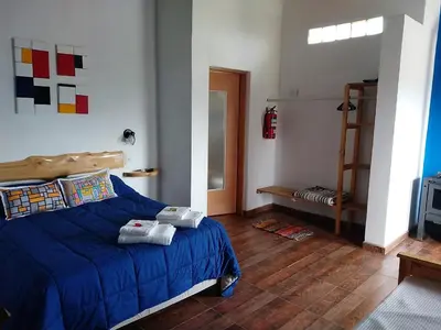 a bedroom with a blue bed with towels on it at Abrazados Suites del Valle in Villa Yacanto