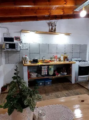 a kitchen with a counter with a sink and a stove at Abrazados Suites del Valle in Villa Yacanto