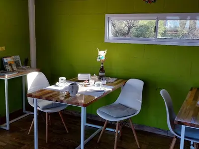 a green room with a wooden table and chairs at Abrazados Suites del Valle in Villa Yacanto