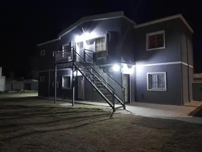 a house with a staircase on the side of it at night at Departamentos Universidad in Río Cuarto
