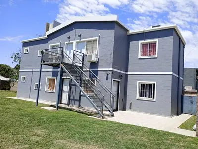 a gray house with a staircase in front of it at Departamentos Universidad in Río Cuarto