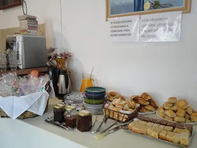 a counter with a bunch of bread and baskets of food at Posada El Betel in Villa Carlos Paz