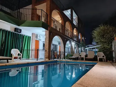 a swimming pool in a building with chairs around it at Posada El Betel in Villa Carlos Paz