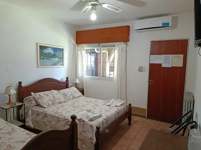 a bedroom with a bed and a window and a door at Posada El Betel in Villa Carlos Paz