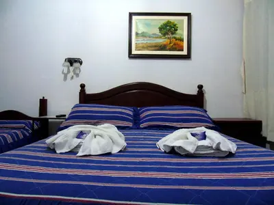 a bed with blue and white sheets and towels on it at Posada El Betel in Villa Carlos Paz