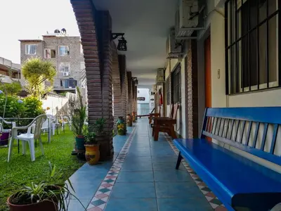 a blue bench sitting on the side of a building at Posada El Betel in Villa Carlos Paz