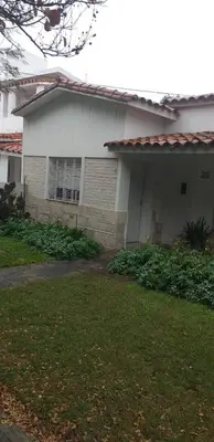 a white house with a grass yard in front of it at Alojamiento Taravella in Cordoba