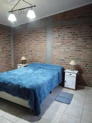 a bedroom with a blue bed and two night stands at Casa del viñedo in Villa de Las Rosas