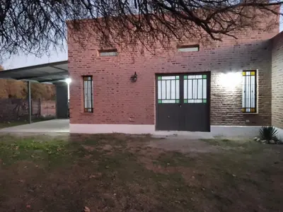 a brick building with a black door on the side at Casa del viñedo in Villa de Las Rosas