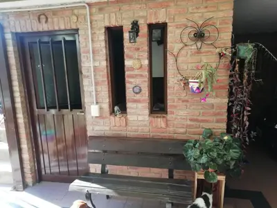 a brick wall with a bench and a plant at La casa de Lily in Alta Gracia