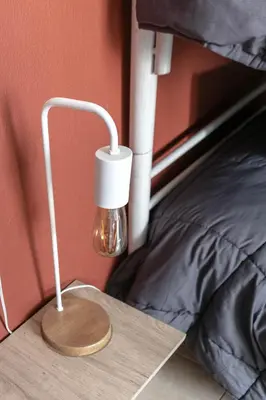 a lamp sitting on the corner of a bed at Departamentos Meraki in Villa Carlos Paz