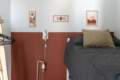 a bedroom with a bed and some pictures on the wall at Departamentos Meraki in Villa Carlos Paz