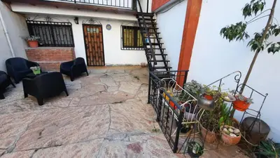 a patio with a spiral staircase in front of a house at Departamentos Meraki in Villa Carlos Paz