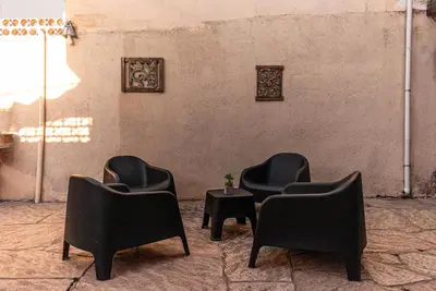 three black chairs and a table in a room at Departamentos Meraki in Villa Carlos Paz