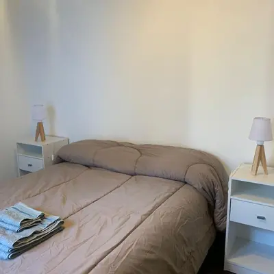 a bedroom with a bed with two night stands and two lamps at Hipólito Yrigoyen 150 in Cordoba