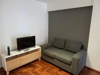 a living room with a couch and a flat screen tv at Departamento 1 Dormitorio - Buenos Aires 1100 - Nueva Cordoba in Cordoba
