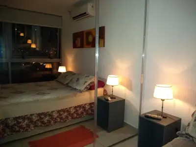 a bedroom with a bed and two lamps and a mirror at Departamentos NG CENTRO Carlos Paz in Villa Carlos Paz