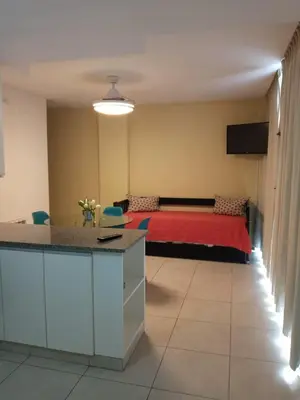 a bedroom with a bed with a red blanket at Departamentos NG CENTRO Carlos Paz in Villa Carlos Paz