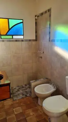 a bathroom with a toilet and a sink and a window at Hospedaje Sauce Linda - Casa Brea in Piedra Pintada