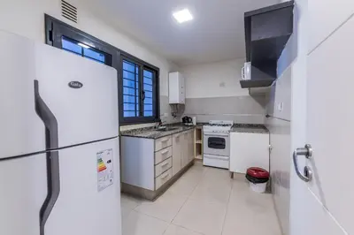 a kitchen with white appliances and a window at Depto Familiar de dos habitaciones By Lofty in Cordoba
