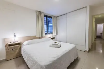 a white bedroom with a large bed and a window at Depto Familiar de dos habitaciones By Lofty in Cordoba