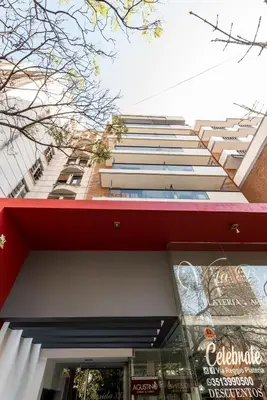 a tall apartment building with a red roof at Depto Familiar de dos habitaciones By Lofty in Cordoba