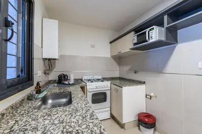 a kitchen with a sink and a stove at Depto Familiar de dos habitaciones By Lofty in Cordoba