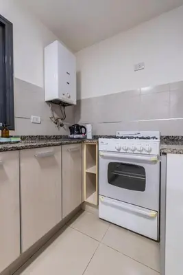 a kitchen with a white stove and cabinets at Depto Familiar de dos habitaciones By Lofty in Cordoba