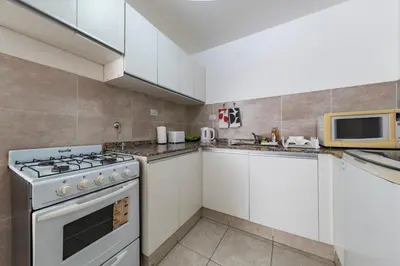 a kitchen with white cabinets and a stove top oven at Viaggiato Obispo Salguero in Cordoba