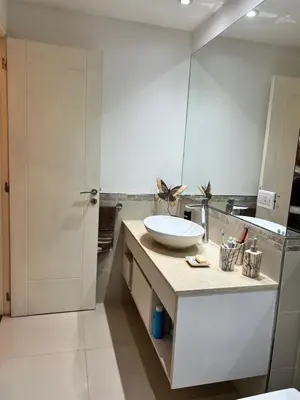 a white bathroom with a sink and a mirror at Departamento amplio y muy iluminado en 9 piso, con piscina in Río Cuarto