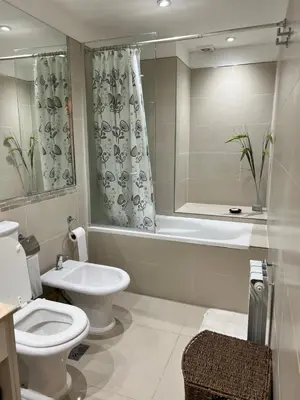 a bathroom with a toilet and a tub and a sink at Departamento amplio y muy iluminado en 9 piso, con piscina in Río Cuarto