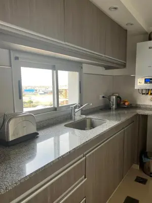 a kitchen counter with a sink and a window at Departamento amplio y muy iluminado en 9 piso, con piscina in Río Cuarto